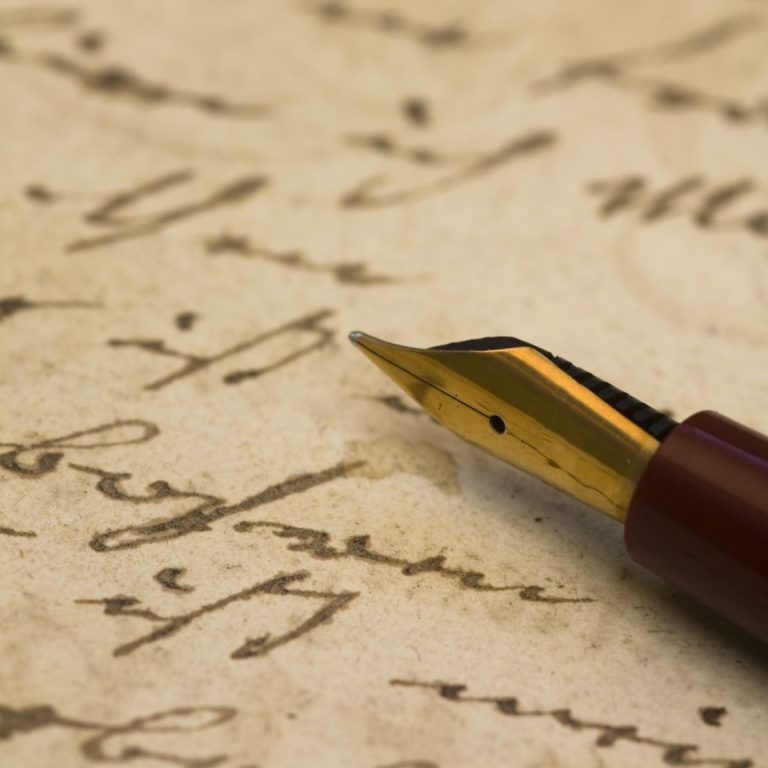 Imagen en la que se ve un texto escrito y una pluma de escribir.